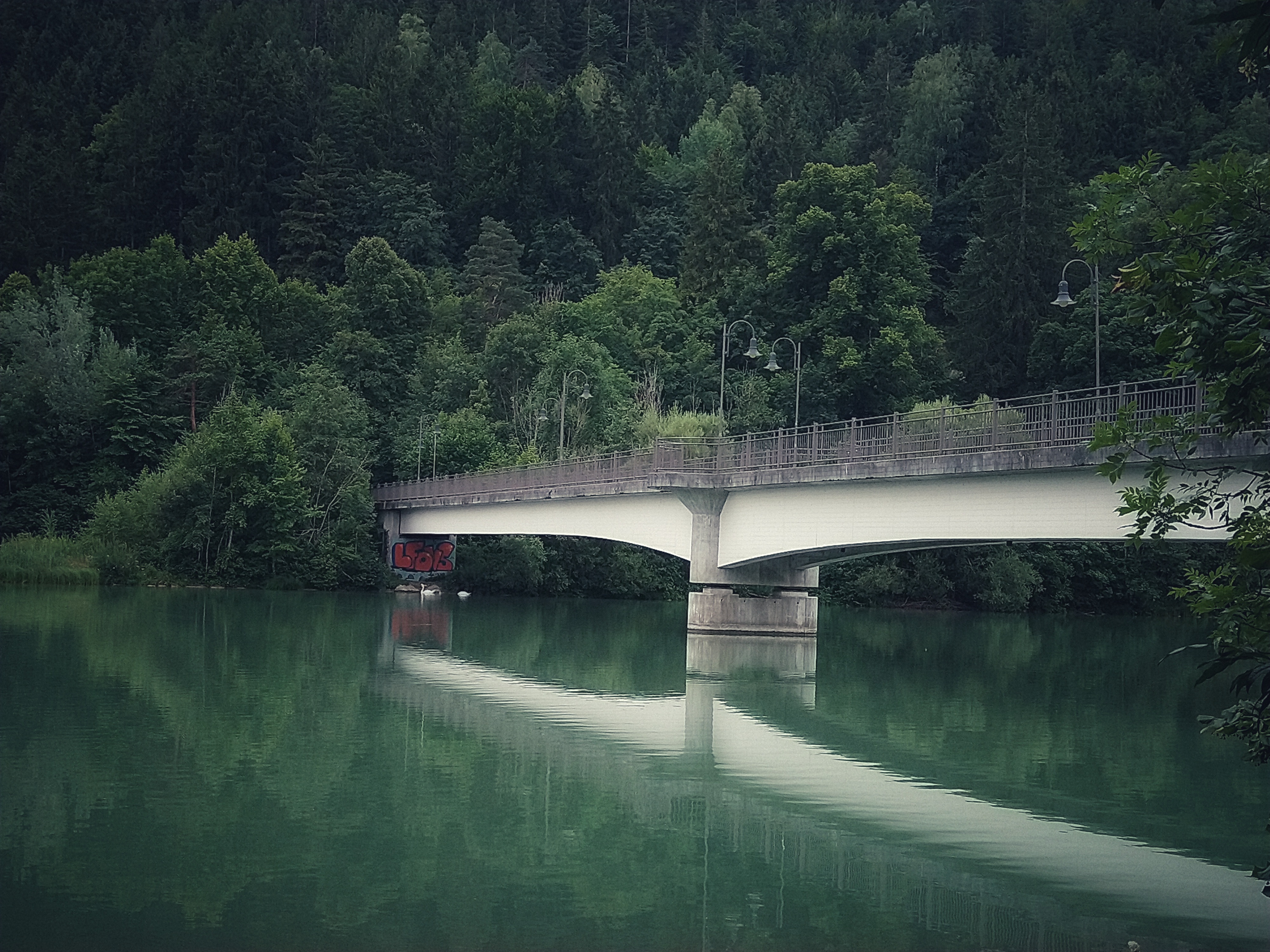 A bridge spanning over a turqoise river.