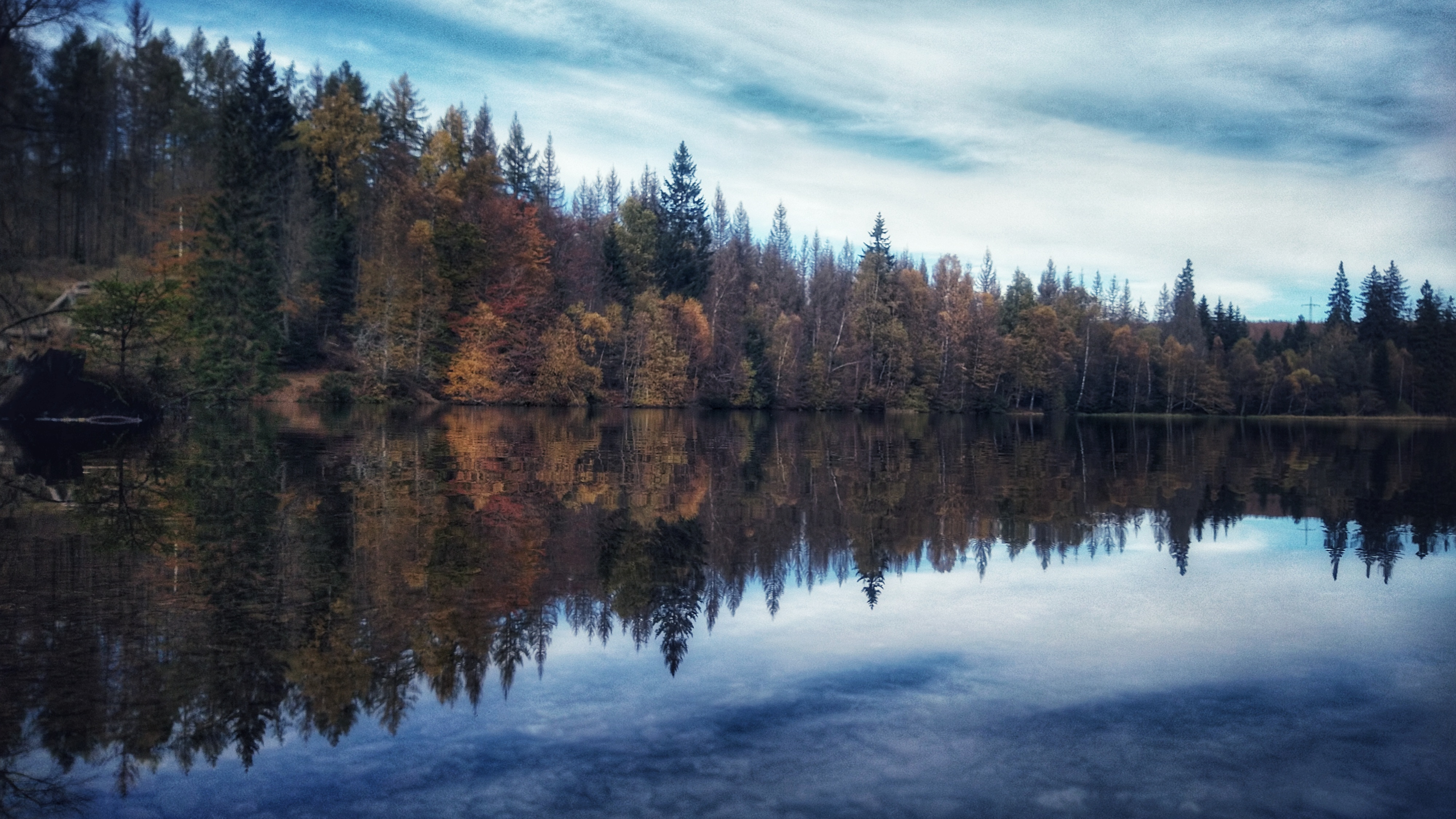 Lake in the midst of a forest. The trees reflect perfectly in the water