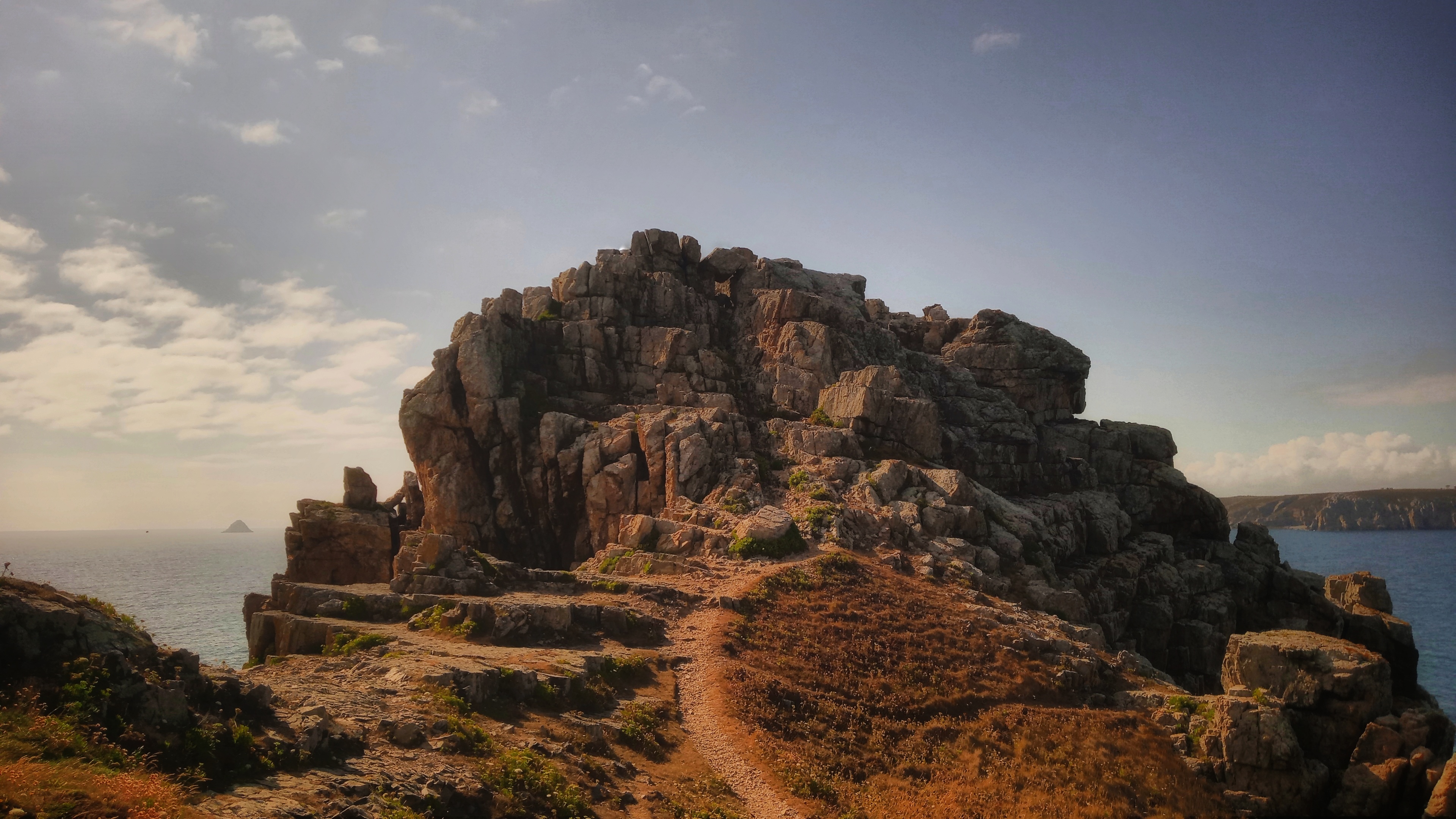 Rock formation with a pathway leading up to it. In the background the french mainland can be made out