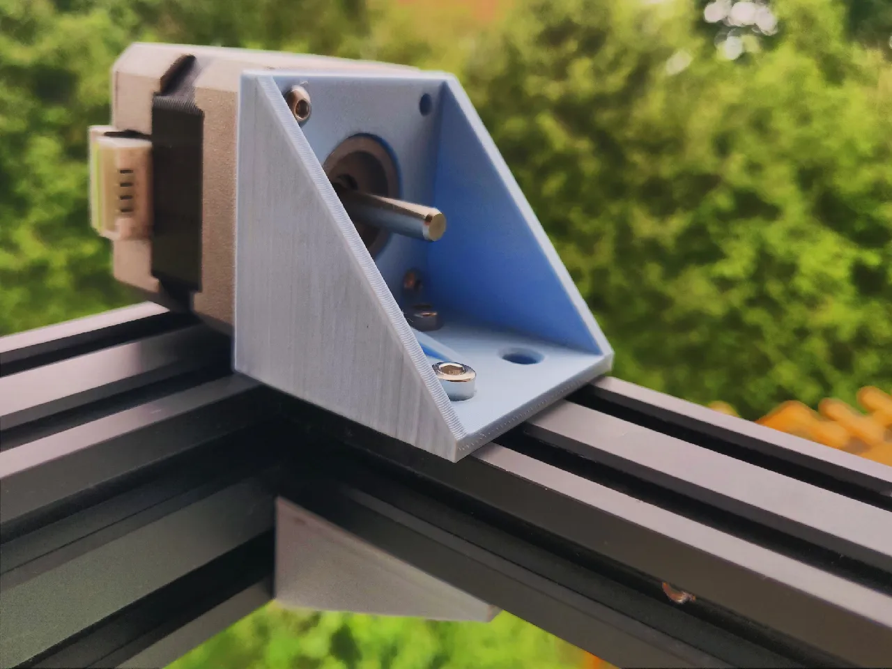 Stepper mount screwed onto a piece of extrusion, with a stepper motor mounted through the back