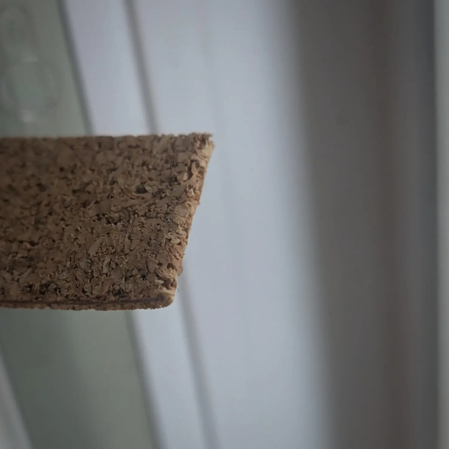 A thin strip of cork folded over onto itself and glued together. You can see small chunks of the material have peeled off from the adhesive backing layer on the edge.