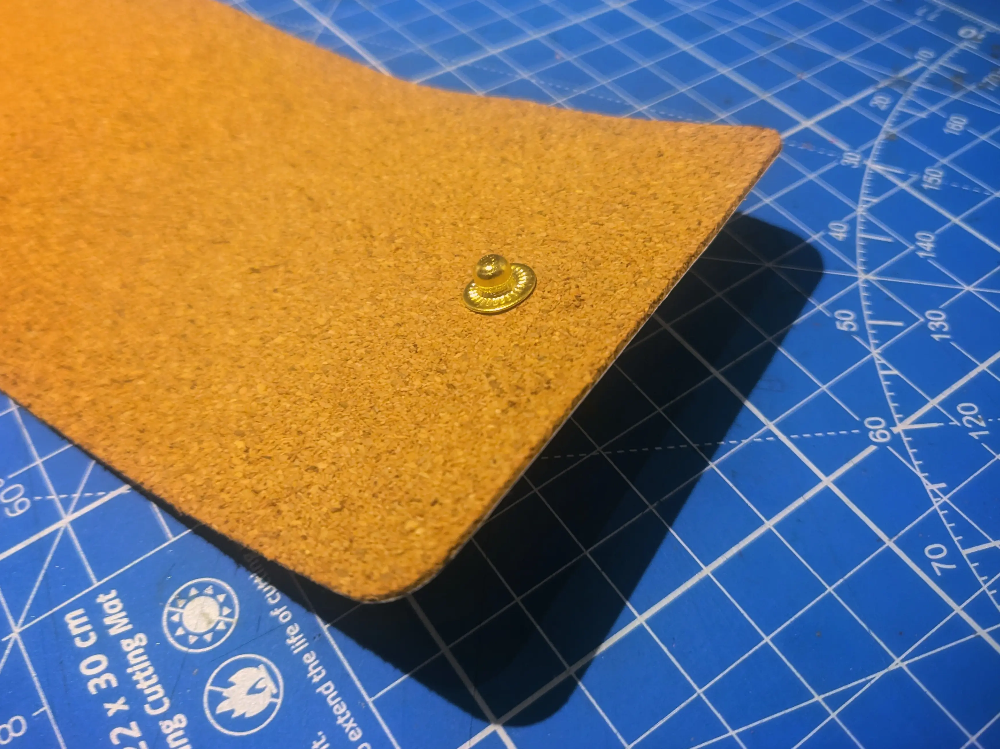 Close-up of the other end of the outer sleeve, where the male part of a snap-button has been installed in the middle.
