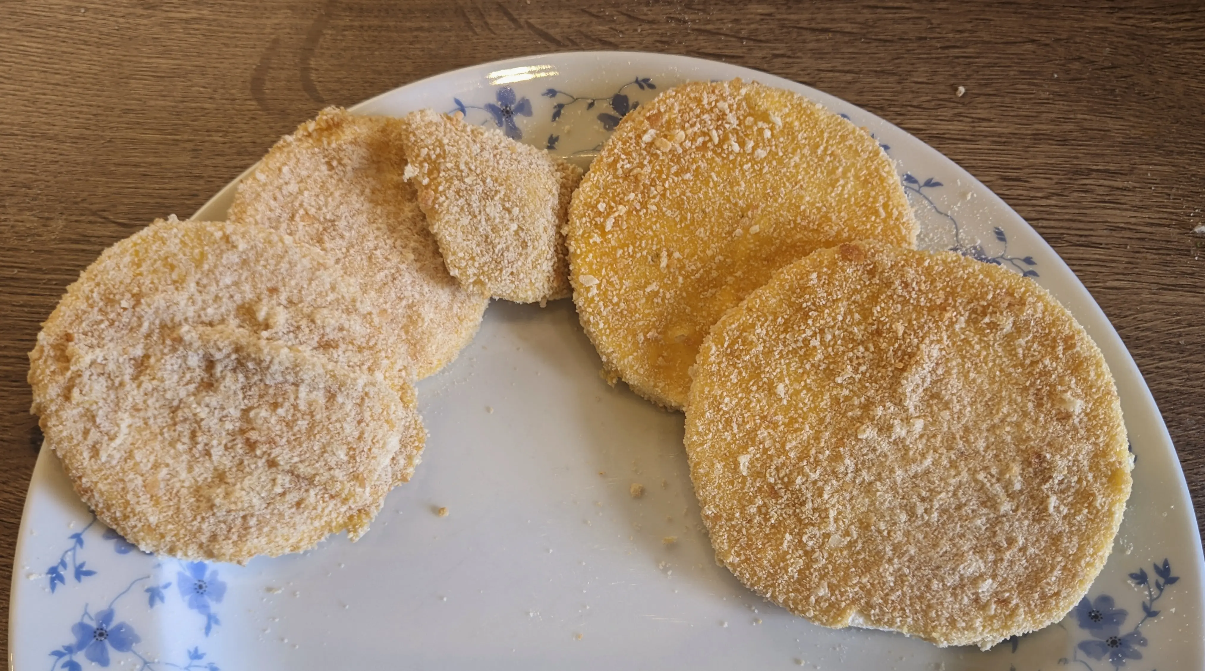 Multiple breaded celeriac slices on a plate