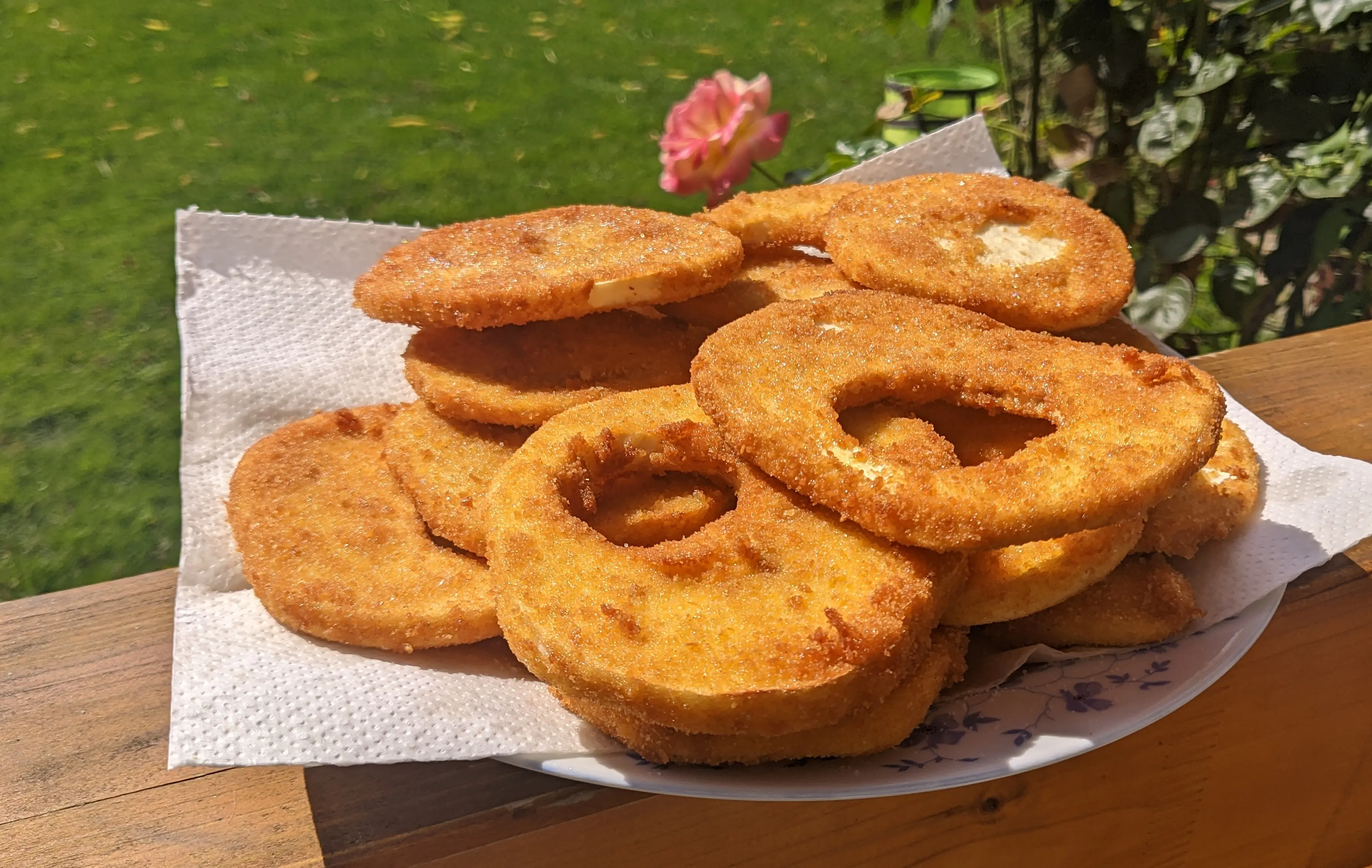 Fried celeriac slices stacked on a plate lined with a kitchen paper.
The slices are disk-shaped and golden-brown, from the breadcrumbs.