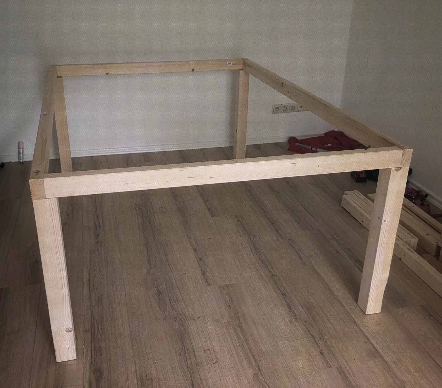 Wooden structure made up of four legs underneath a rectangle made up of wooden beams. Wooden structure made up of four legs underneath a rectangle made up of wooden beams.