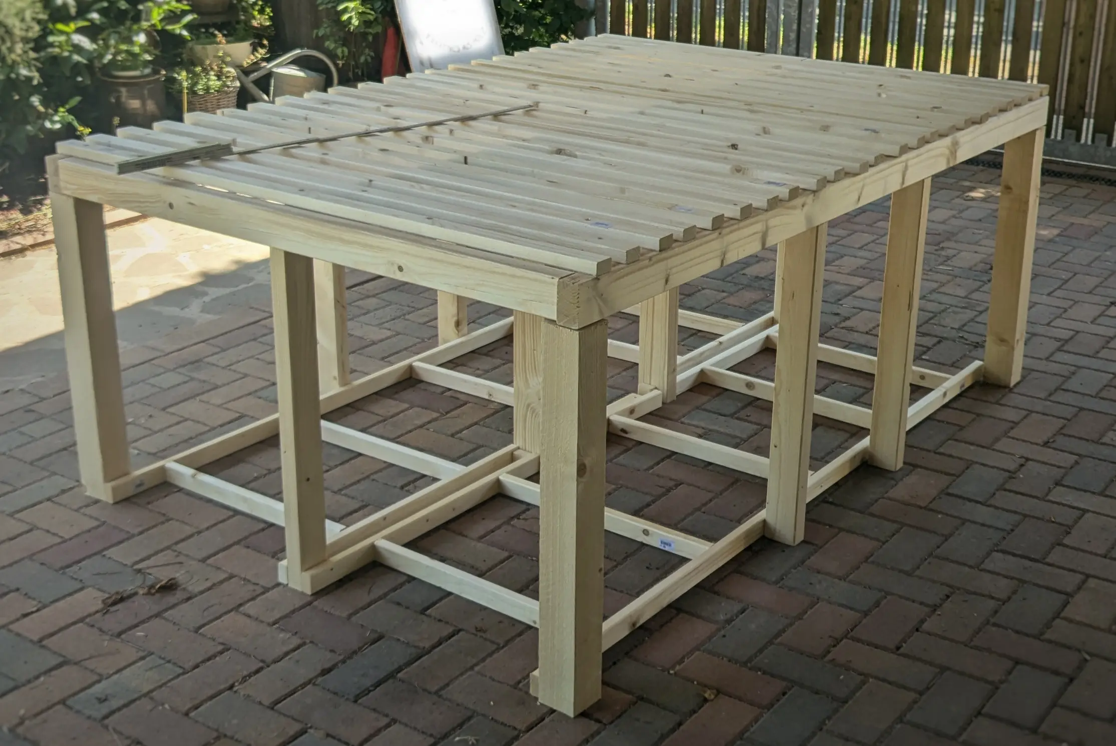 Partially assembled bed base in a driveway.
A sign in the background has been blurred.
The wooden beams aren’t screwed together and partially misaligned, but give a sense of the scale of the bed and show the individual pieces having been cut to the correct length. Partially assembled bed base in a driveway.
A sign in the background has been blurred.
The wooden beams aren’t screwed together and partially misaligned, but give a sense of the scale of the bed and show the individual pieces having been cut to the correct length.