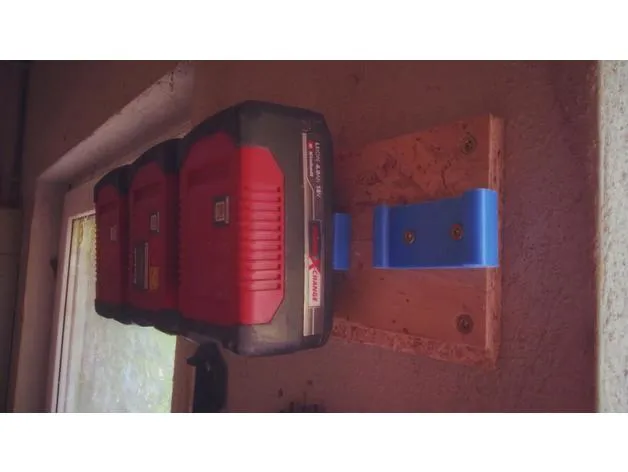 Four battery wall mounts screwed to a wooden plate, hung on the wall. Three of the four mounts have batteries in them.