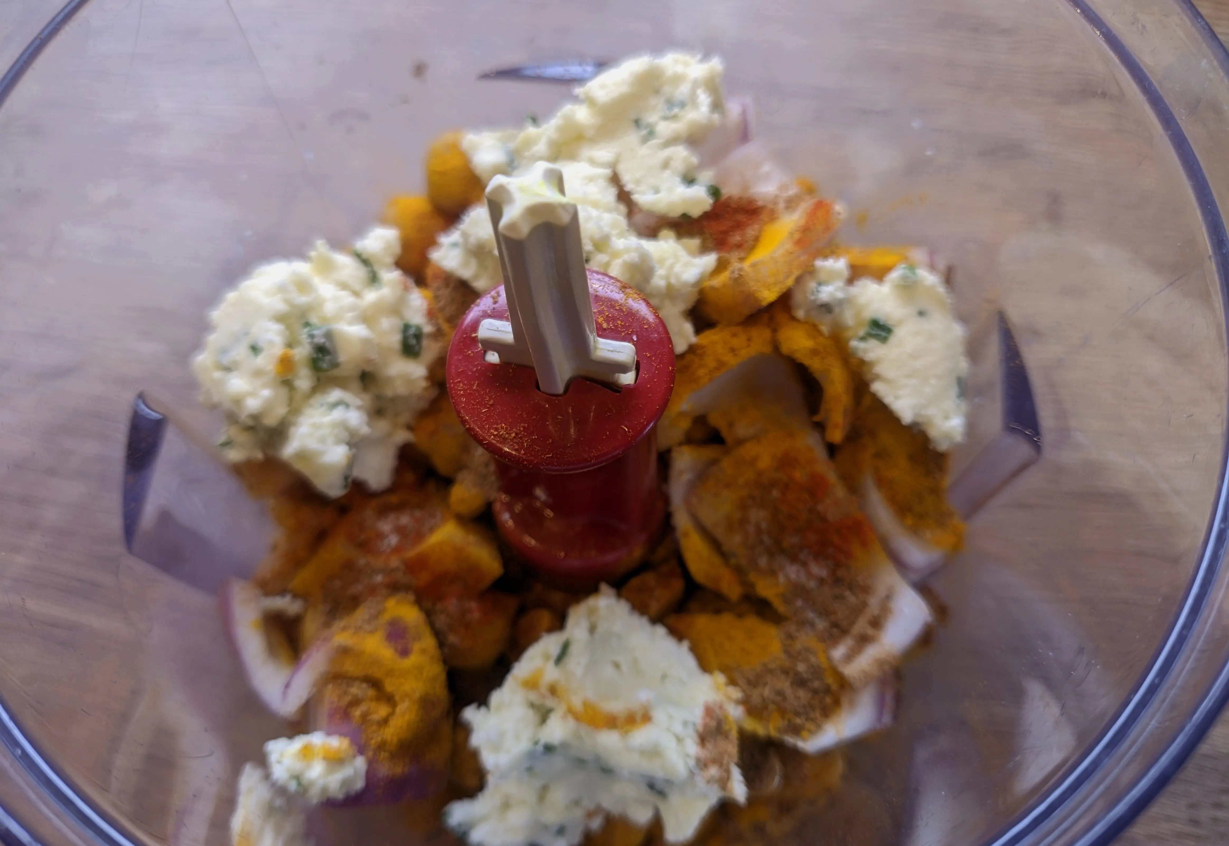 Seasoning and feta mix on top of the chickpeas in the same food processor