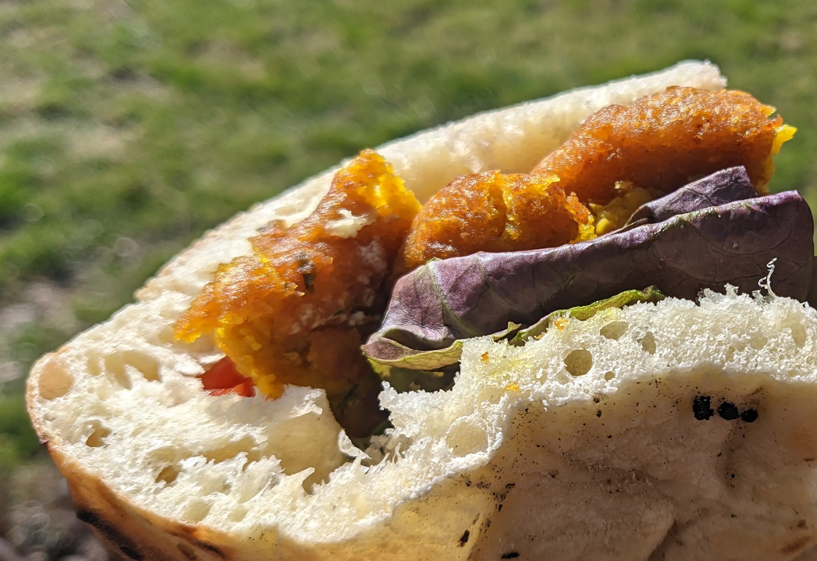 Lettuce and falafel sticking out of a pita bread