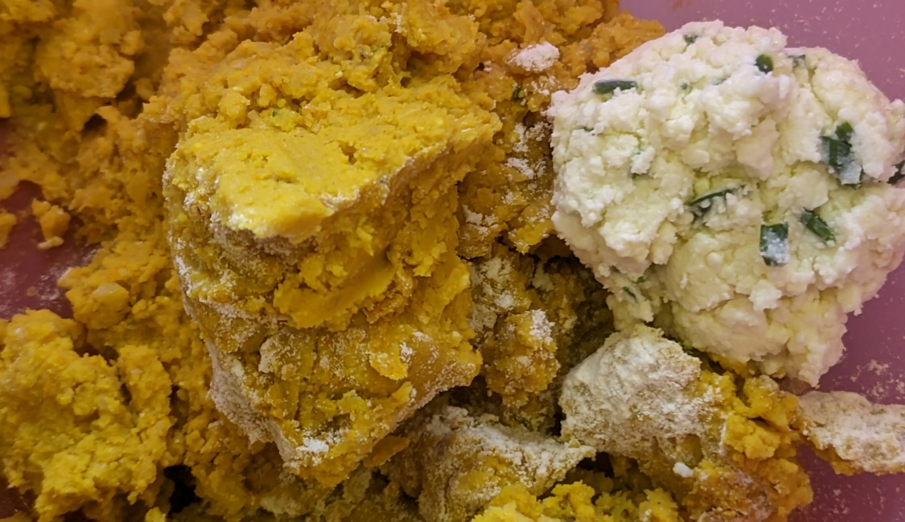 Blended chickpea mash and a ball of the feta mix in a larger mixing bowl.
