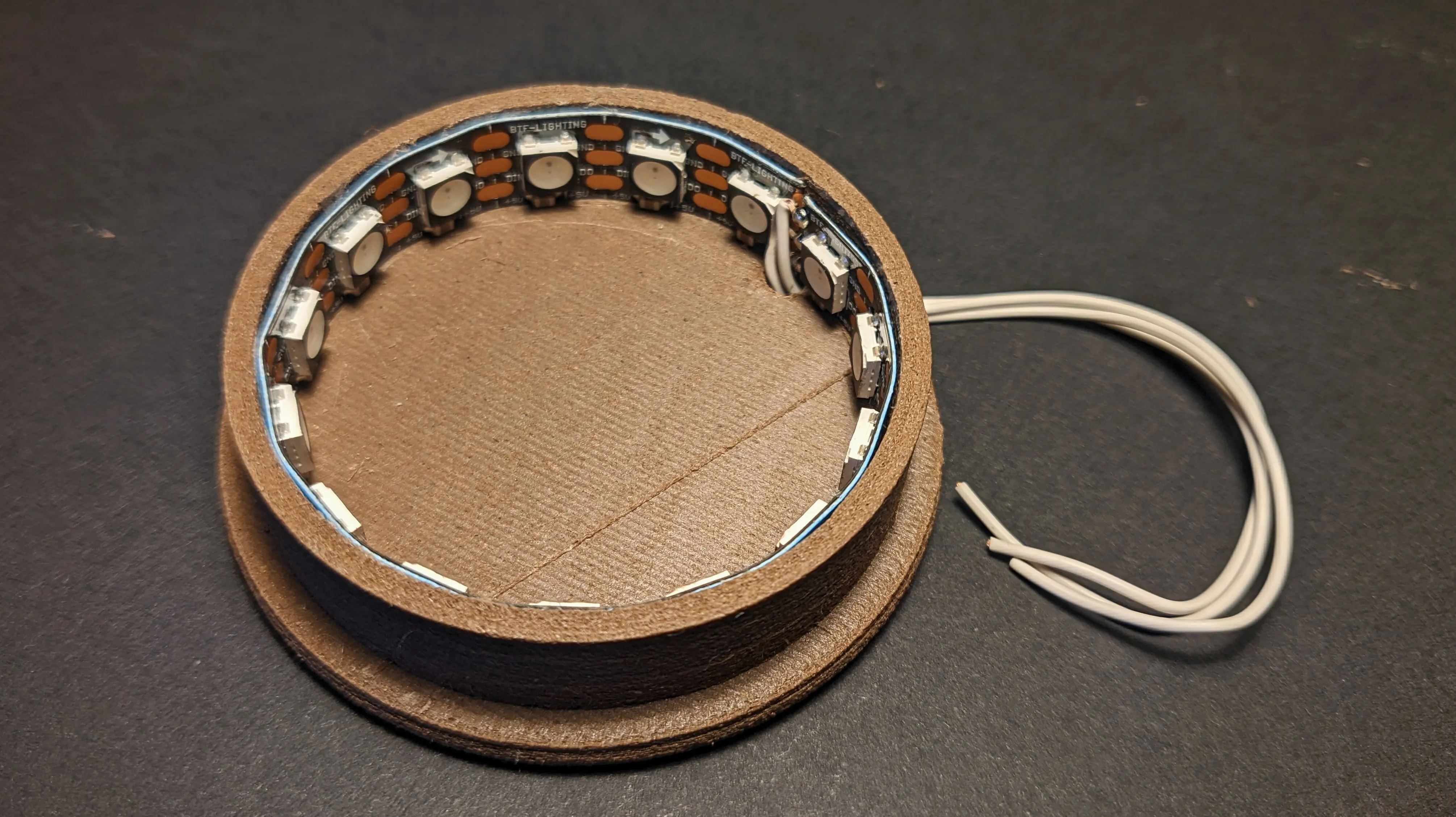 LED strip running along the inside of the bottom cylinder.
Three wires can be seen running through the base plate and out the back.