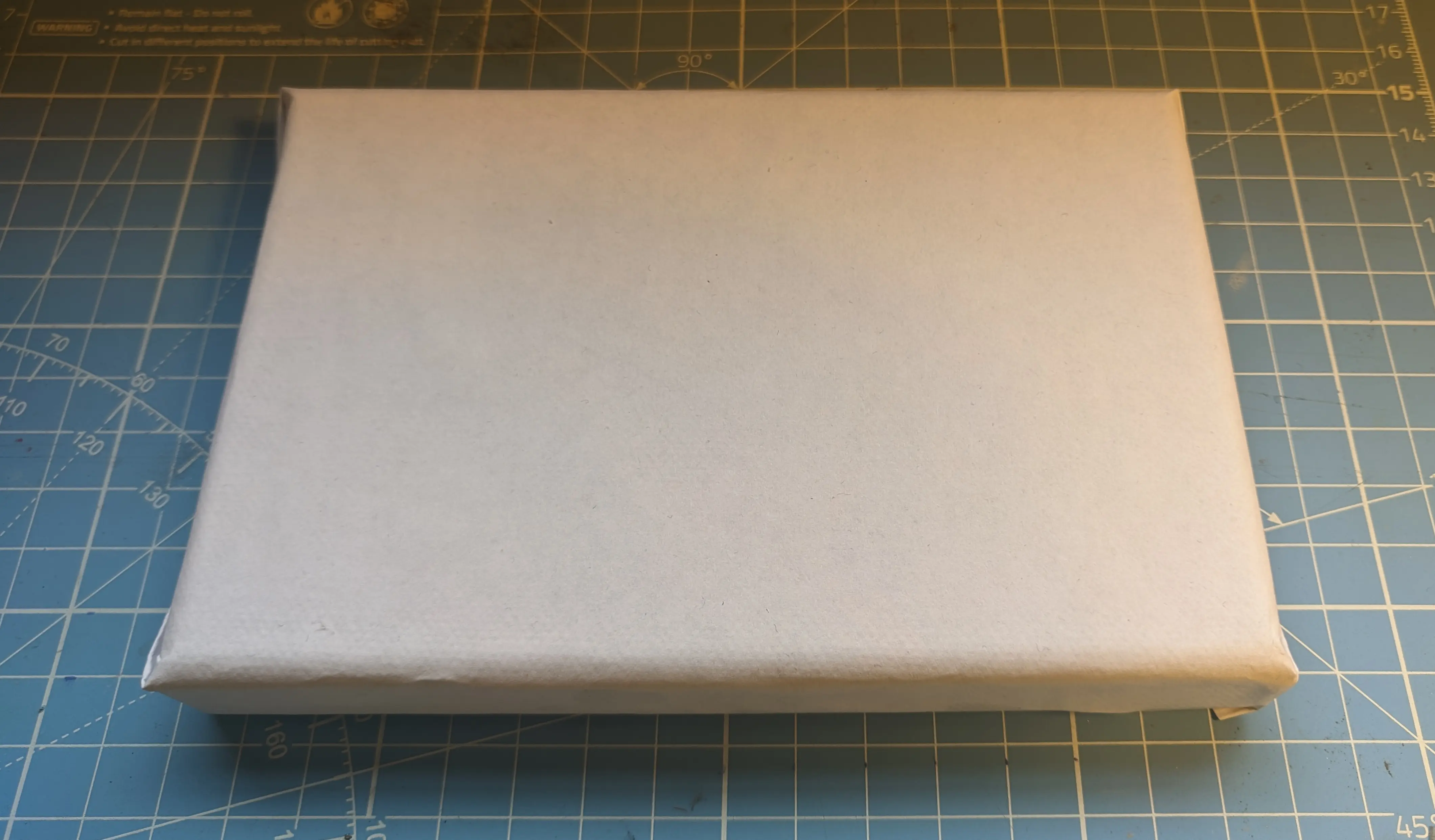paper-wrapped canvas sitting on a plastic cutting mat