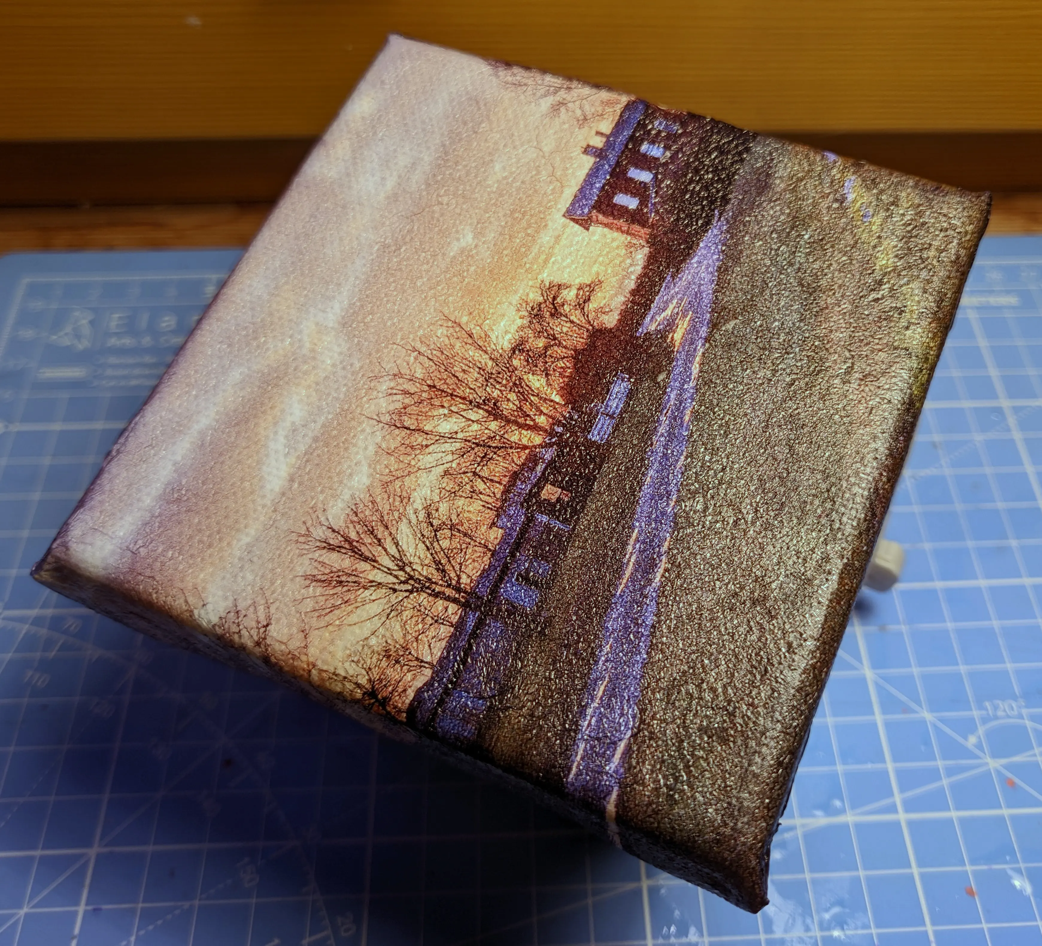 Finished canvas sitting on a small stand. The canvas texture is still visible.