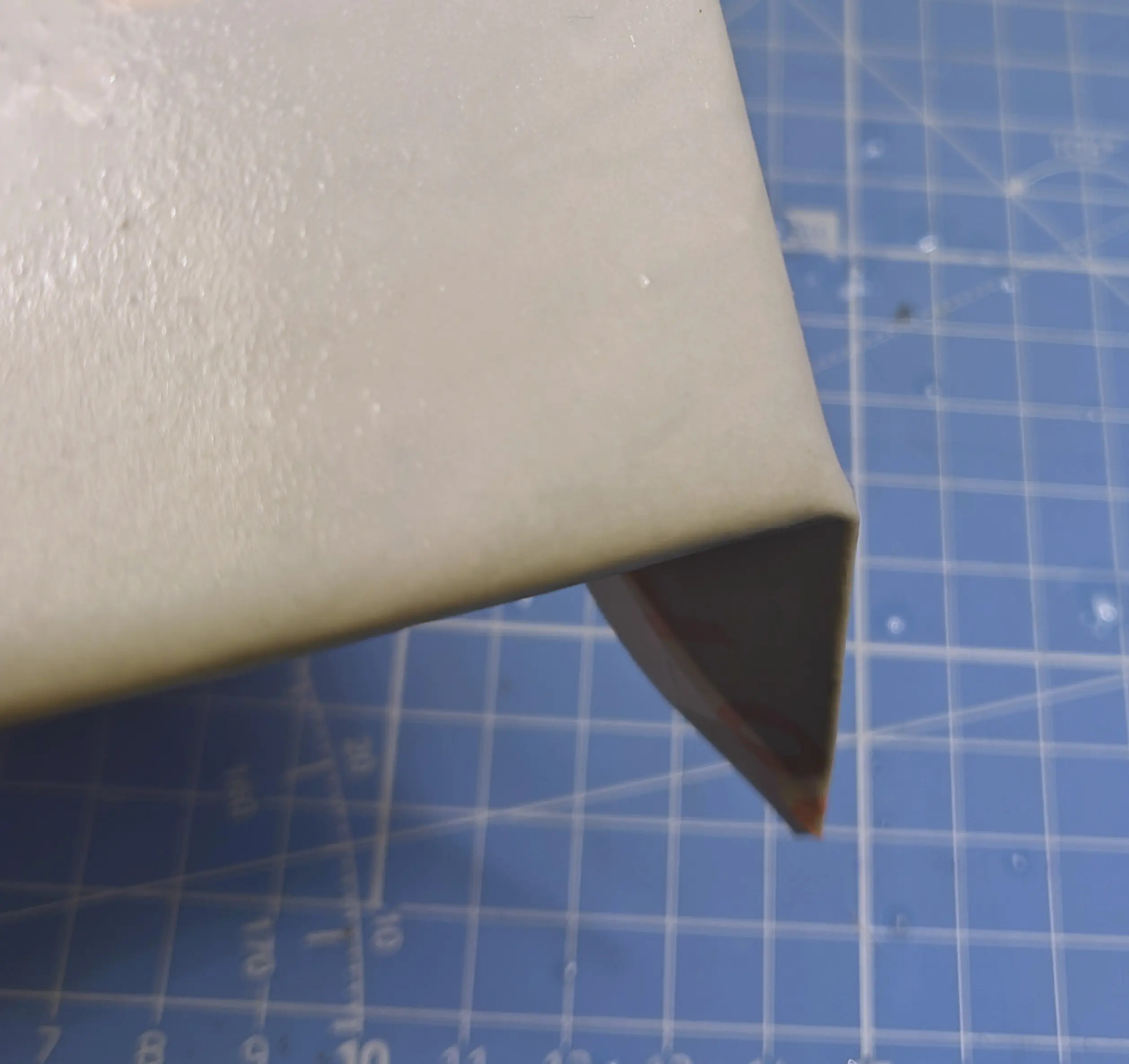 Cropped corner of the canvas. The outer paper layer is wet and a flap has been formed, connecting the plastic films together