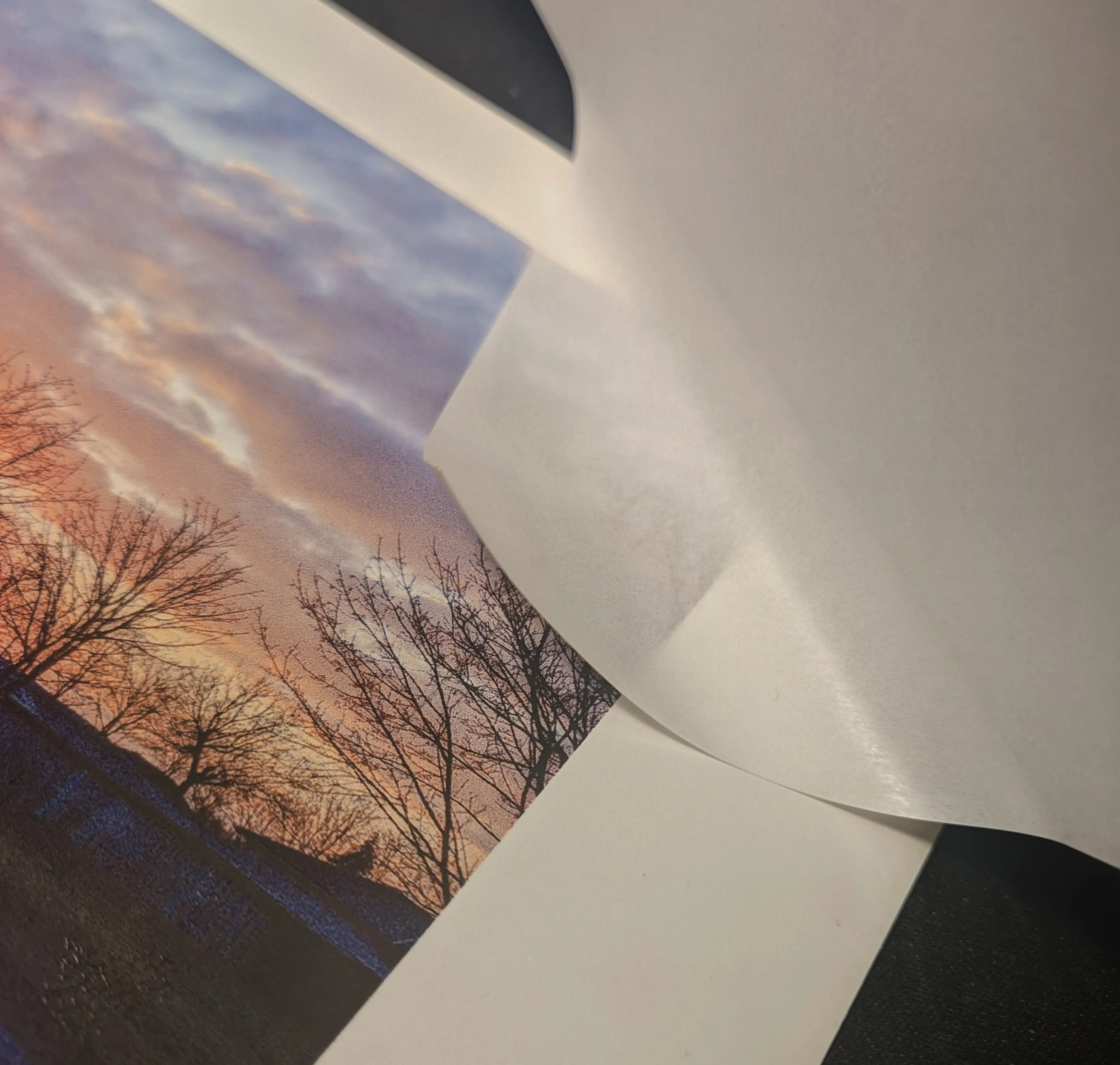 Other side of the glued down corner section, showing the protective paper sheet being pulled away