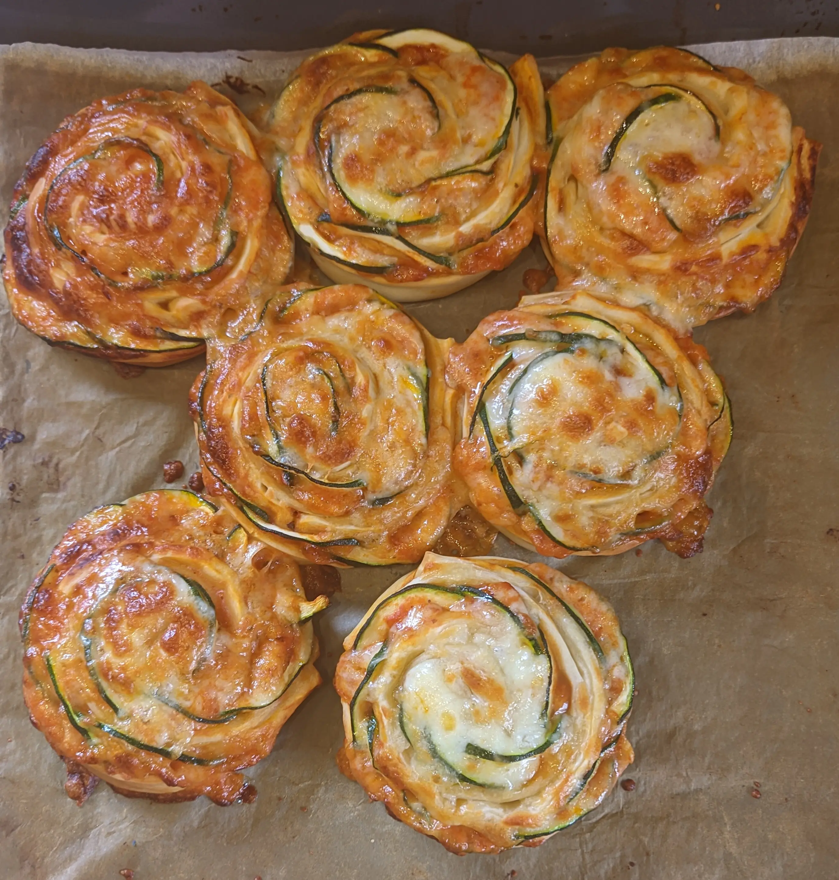 Top-down view of the baked rolls. The cheese melted into a golden-brown layer.