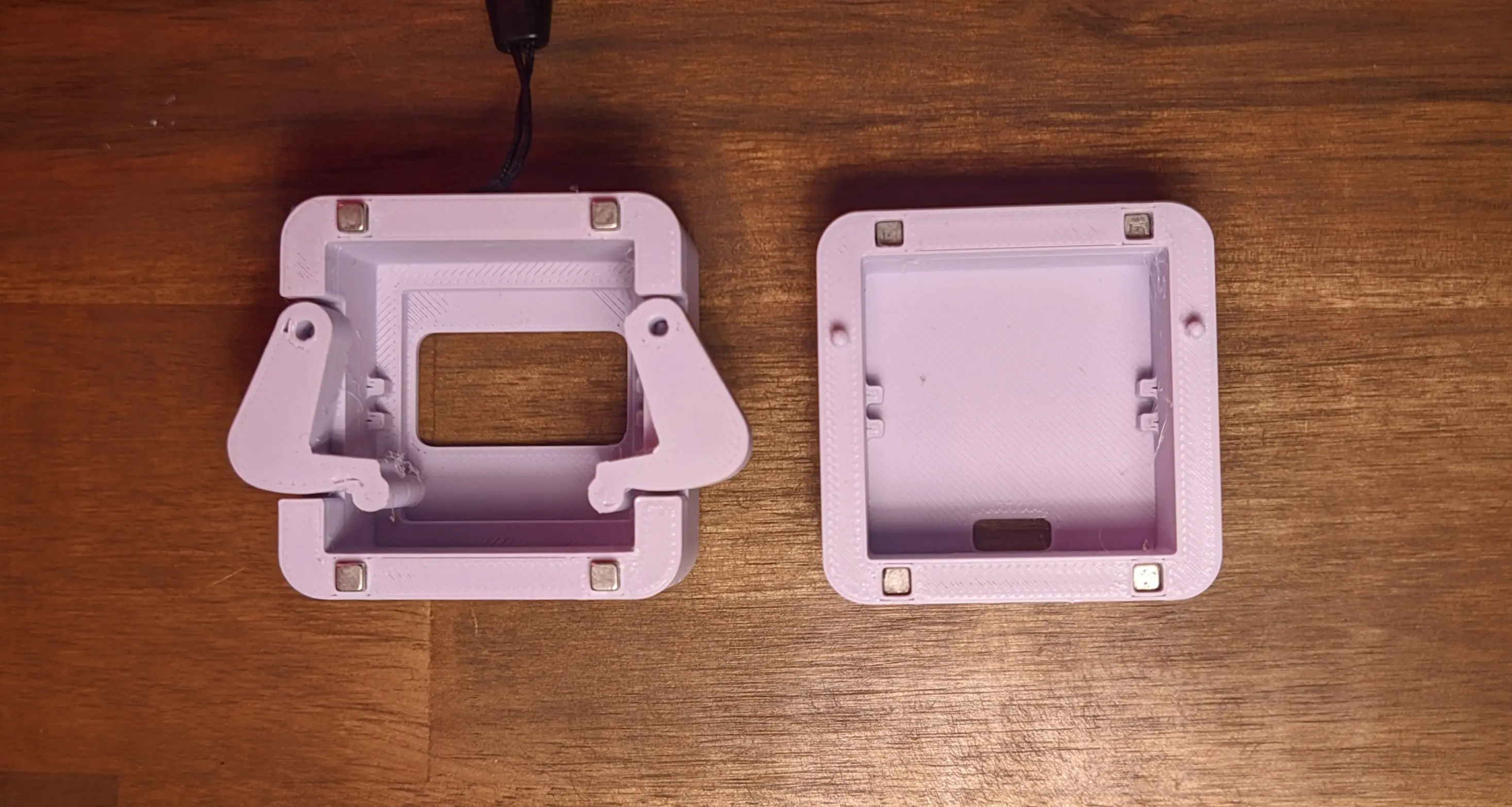 Top-down view of two case parts. The left case appears to be the front half, with a cutout and recess for the display and arms mounted on the sides.
The right part is the back, with a USB-C cutout on the back.