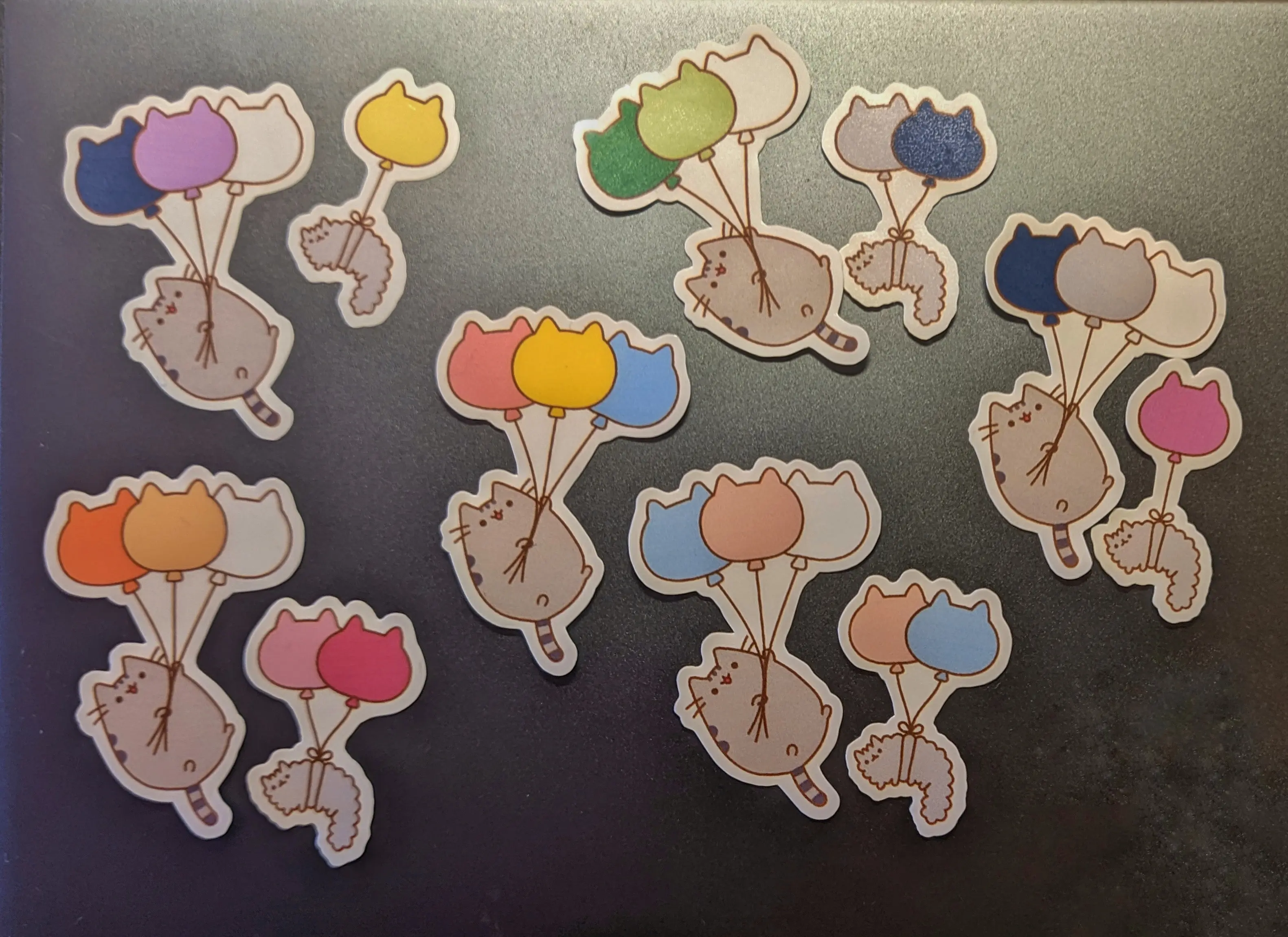 Cutout pride stickers on a dark surface. Only the non-binary set is glued down.