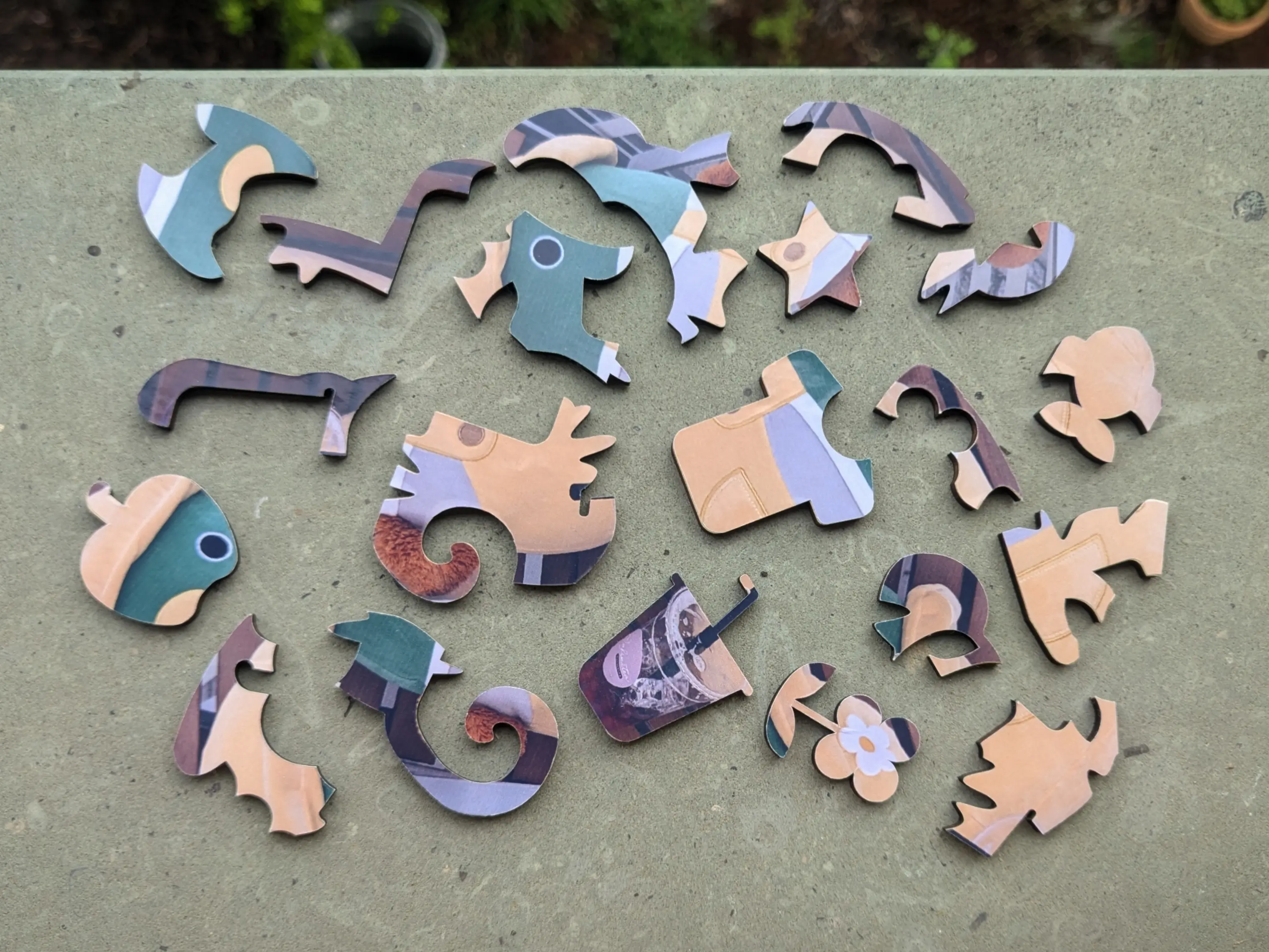 Puzzle pieces of the duck puzzle shown above are randomly placed on a stone.
You can once again make out the random puzzle shapes and the object shapes.
In addition to the themed objects that were visible before, you can now also see a flower and an apple.