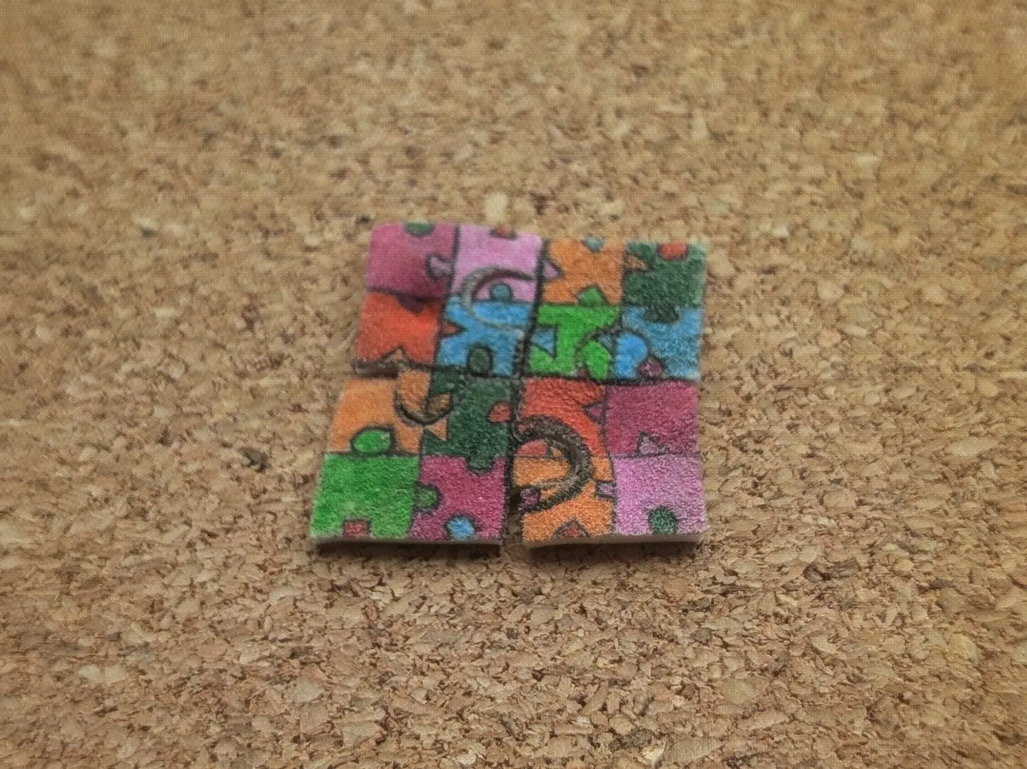 The same four puzzle pieces on a wooden surface. This time they have been assembled as one large square.
On closer inspection you can see how the puzzle pieces don&rsquo;t align properly with one another and are slightly skewed overall.