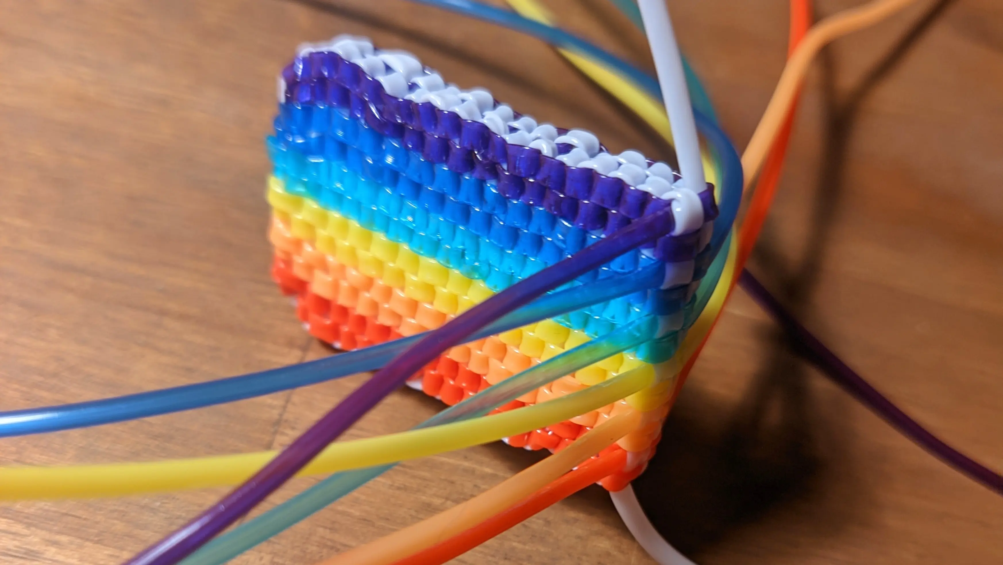 Rectangular rainbow flag with the strands still sticking out the end.