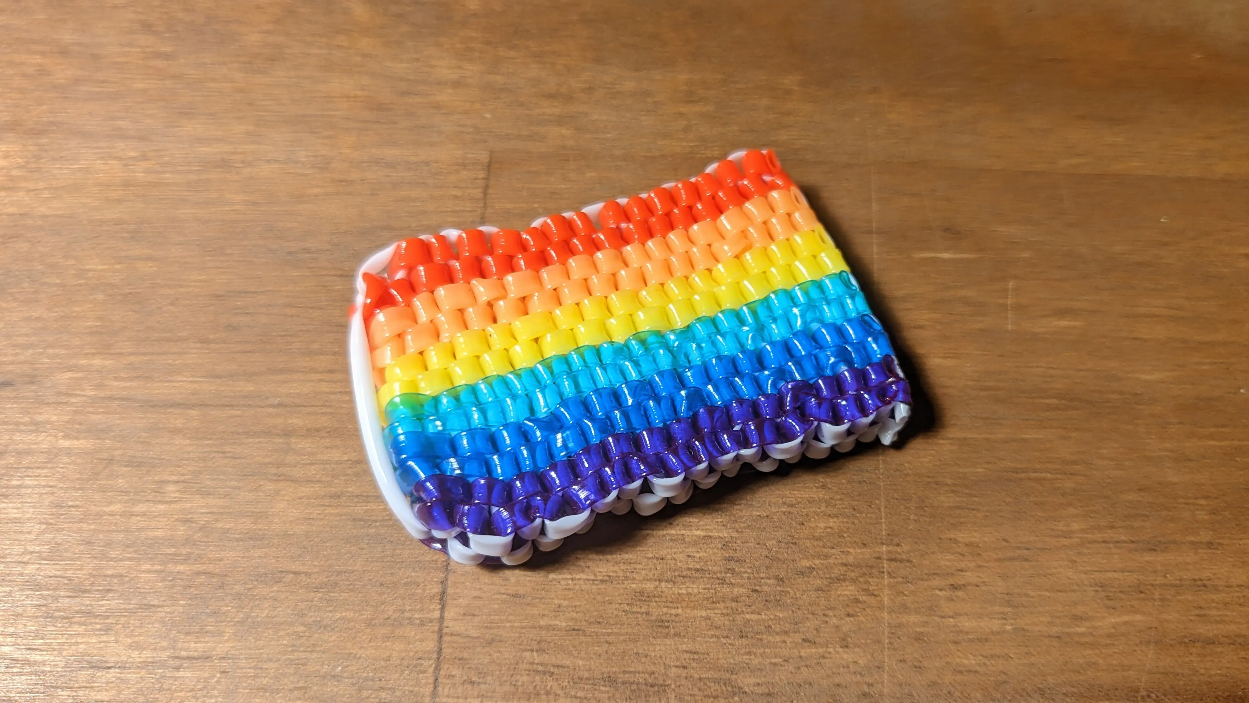 Finished rectangular flag with the excess strands cut off flat.
The edge of the flag is white from the cross strands, and at the end is a single white strand from the first knot.