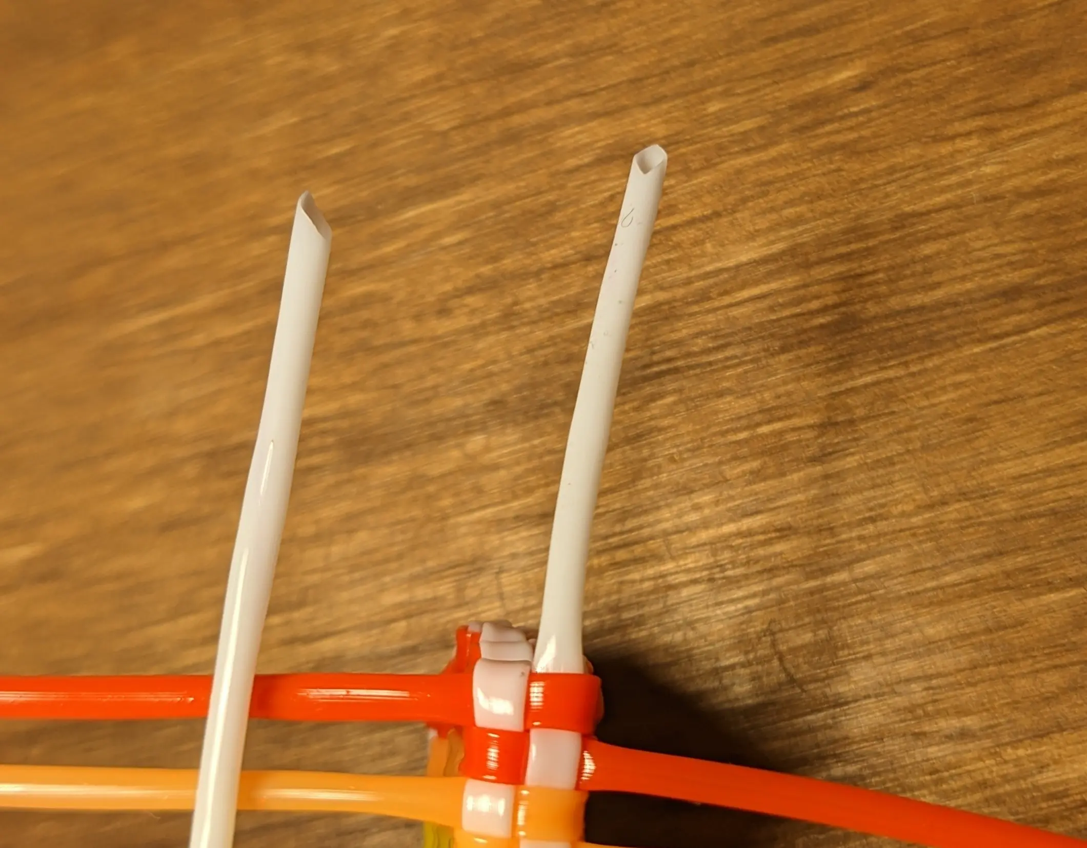 Closeup of the white strand connected to the flag and a new white strand, both being cut at a 45-degree angle