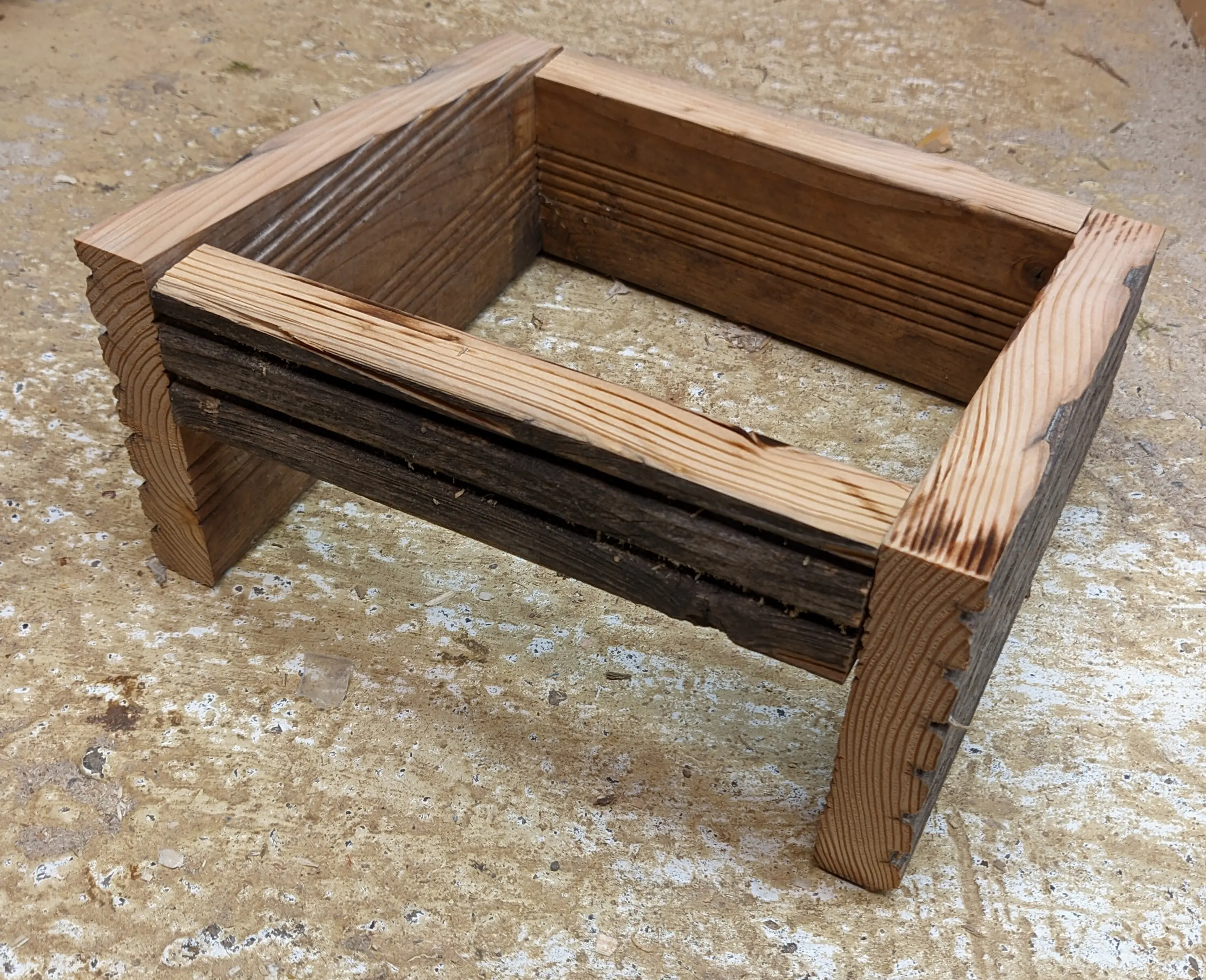 The wooden side pieces screwed together to reveal the hut with a front entrance.