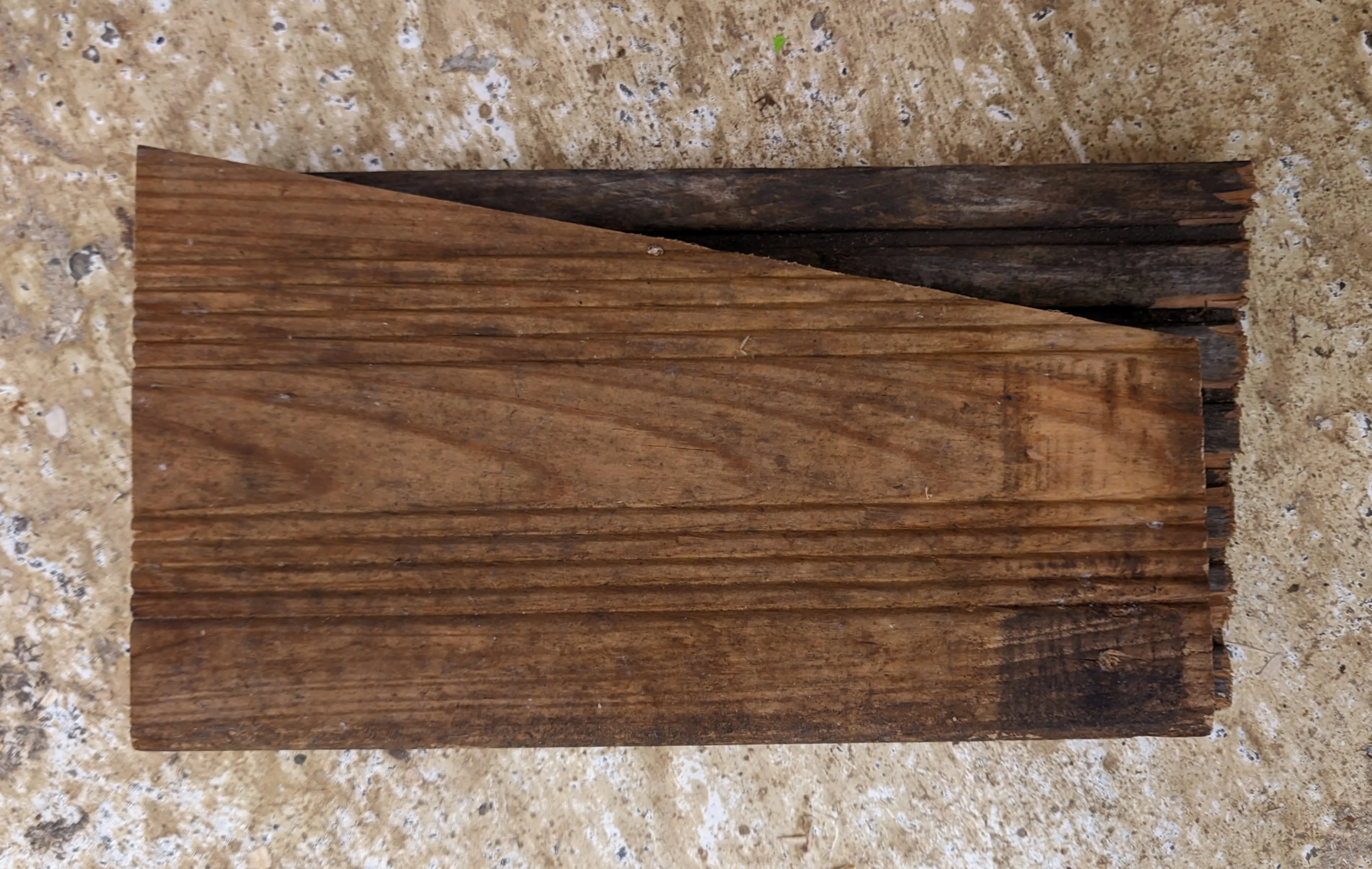 The finished wall piece, lying on top of the smallest of the wooden scrap pieces. The left and bottom edges align, making it possible to trace the top and right edges as well.