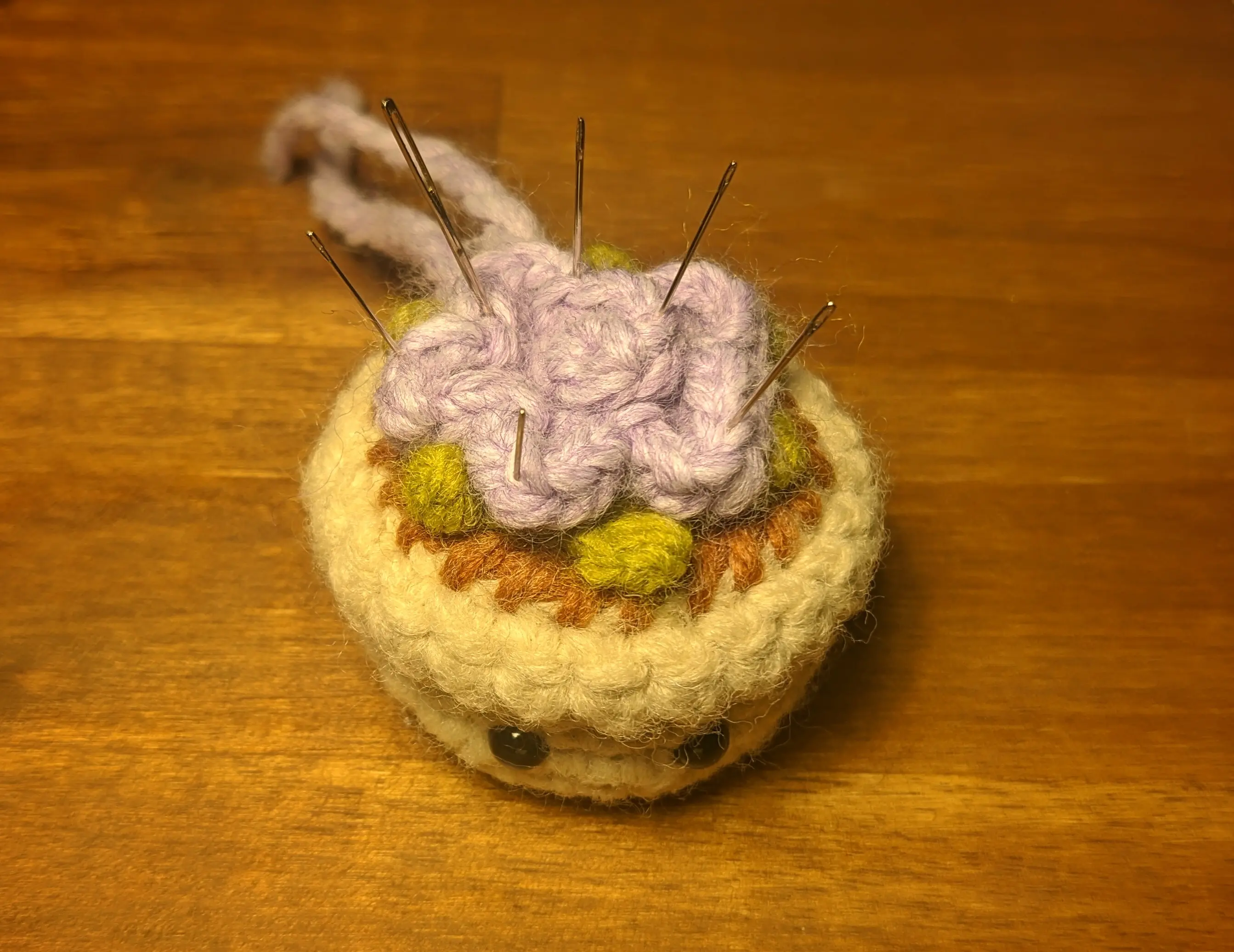 Picture of the flowerpot with the sewn-on leaves. The flower petals have been pinned back in place using needles.