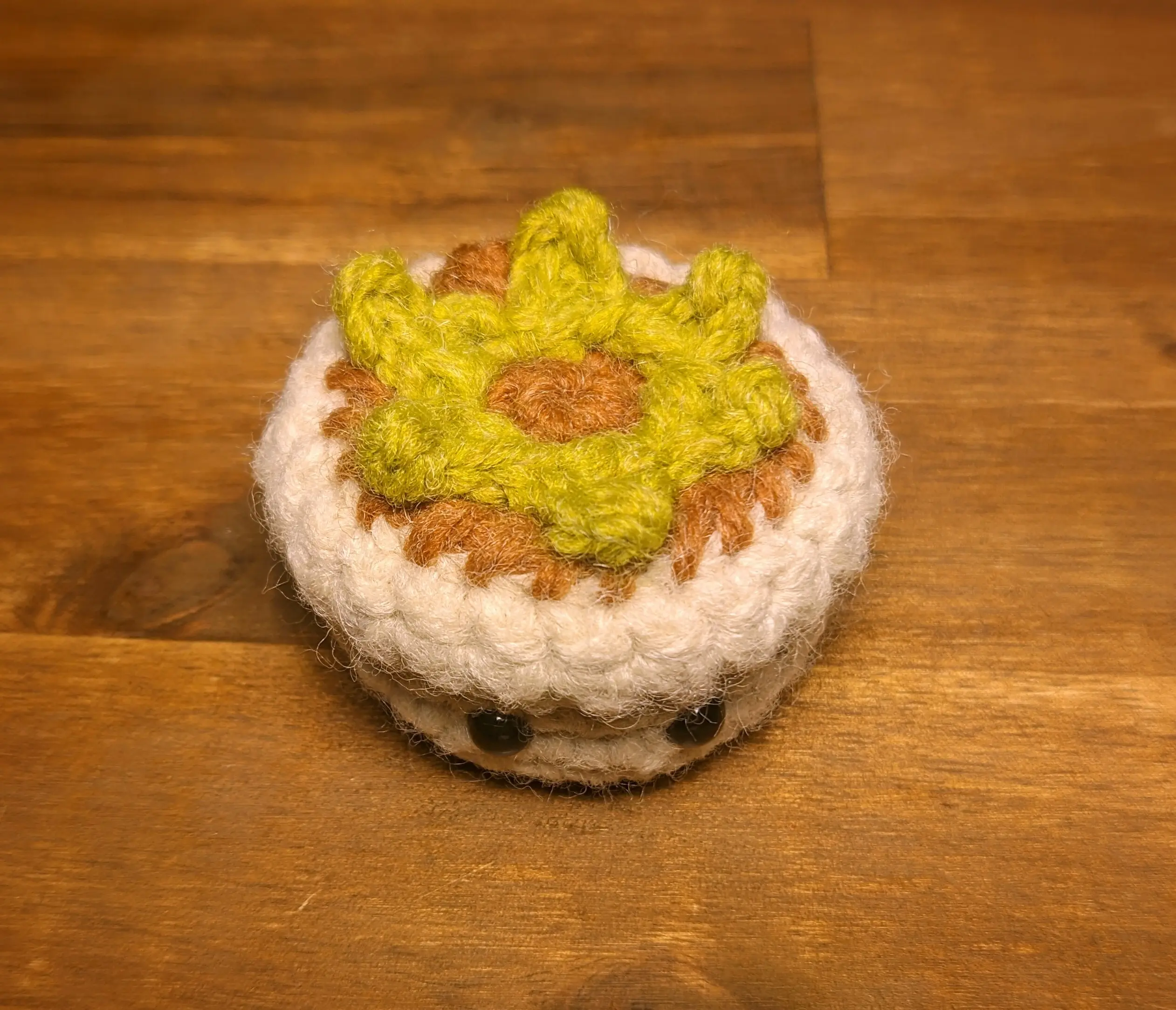 The strip of leaves sewn onto the flowerpot. The petals are no longer placed on top, making it easier to see how the leaves form a circle on the inside, pointing outwards and curling slightly upwards.