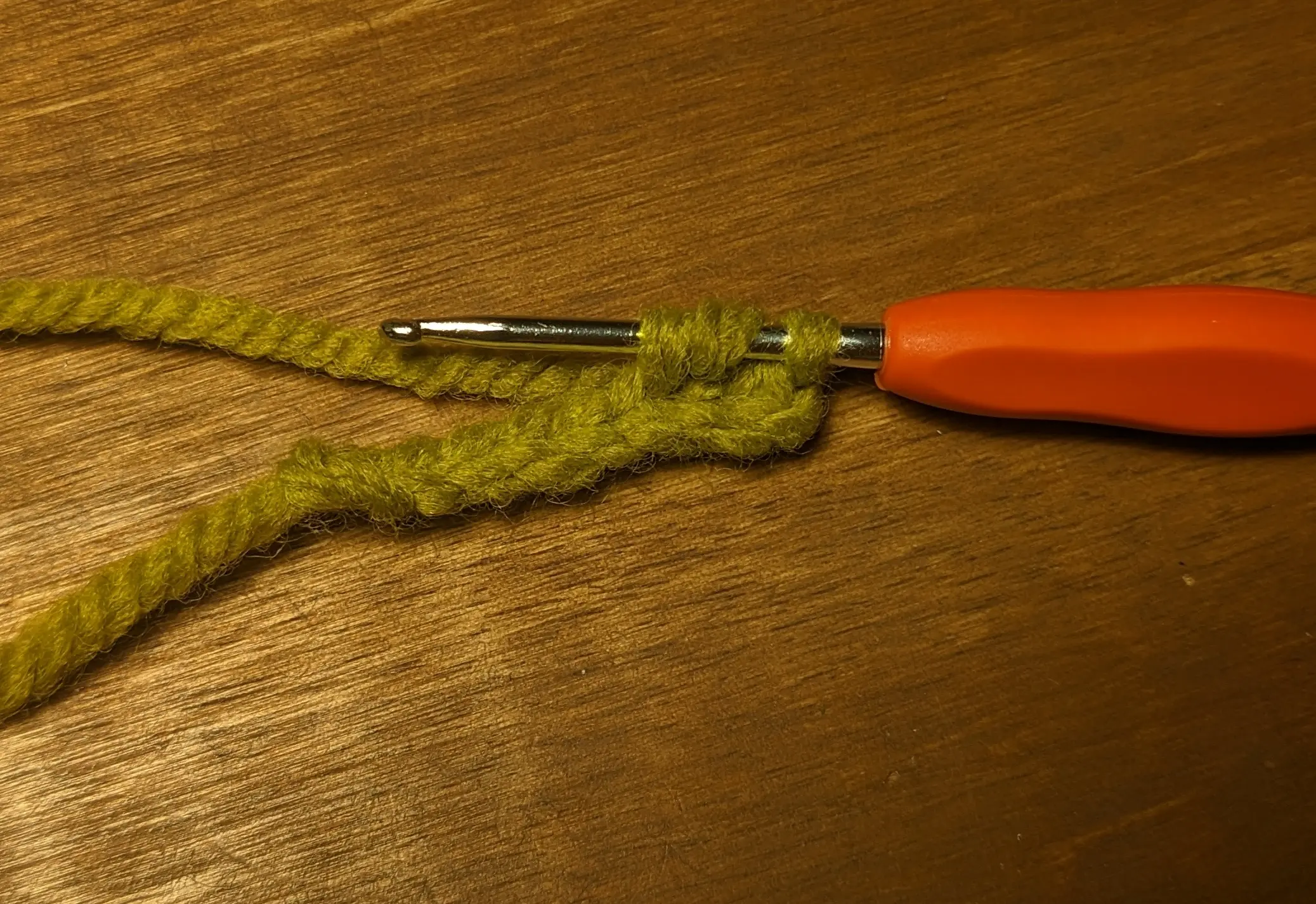 Crochet hook stuck closer to the chain with three loops on it.