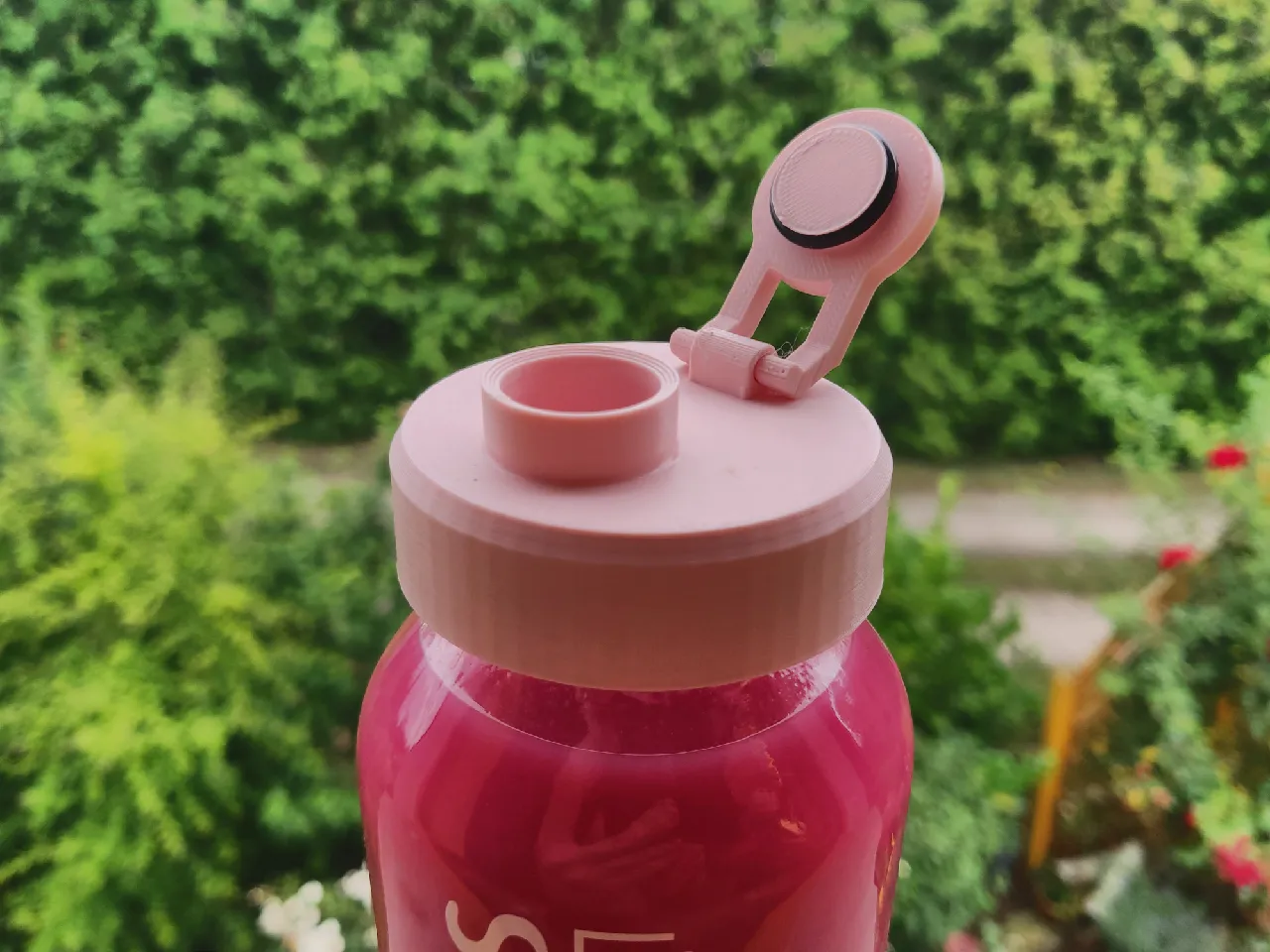 The same cap, but with the lid hinged open, revealing a rubber gasket around the lids inside and a bevel edge inside the mouthpiece